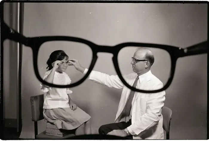 Framed Print : Doctor Puts Glasses on Girl Framed Print : Doctor Puts Glasses on Girl
