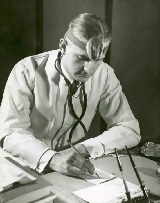 Framed Print : Doctor writes at his desk Framed Print : Doctor writes at his desk
