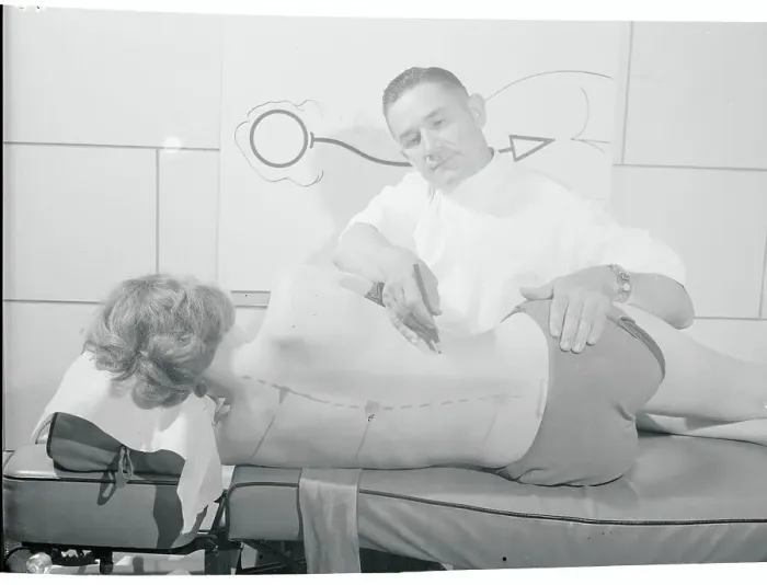 Framed Print : Doctor Writing on Woman's Back Framed Print : Doctor Writing on Woman's Back