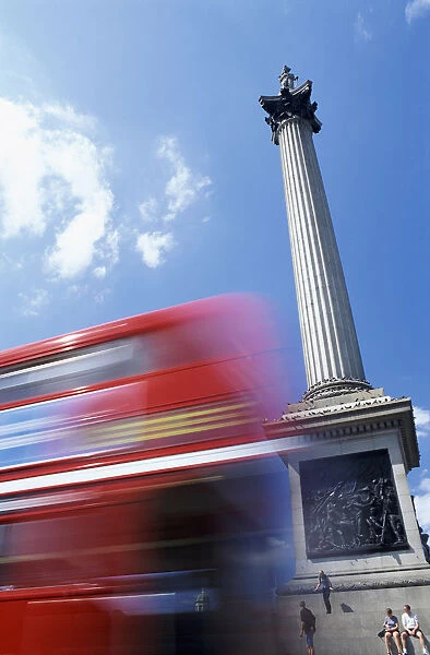 Double Decker Bus Driving past Nelsons Column on Trafalgar Square, Tourists Sitting on Steps, London, UK