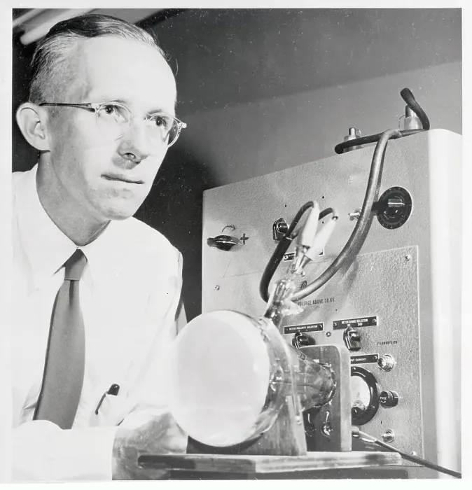 Framed Print : Dr. Edwin Muller Examining Microscope Display