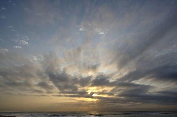 Dramatic clouds at sunrise over the Indian Ocean at Estuary Beach, St Lucia, Kwazulu Natal, South Africa