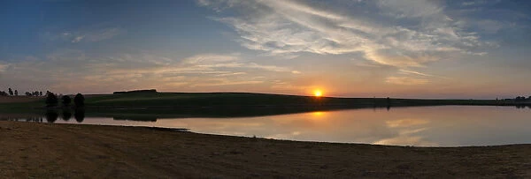 Dramatic panoramic sunset landscape photo over a peaceful remote and isolated farm lake. Kwazulu-Natal, South Africa