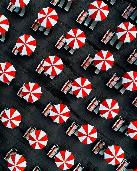 Drone image directly above beach umbrellas, Massa, Italy