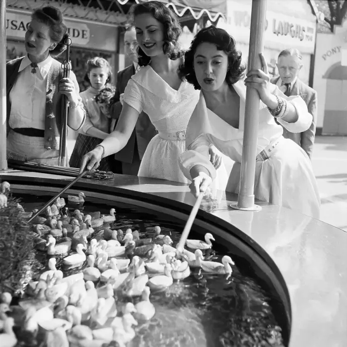 Framed Print : Duck Hook. 20th June 1953: Two young women hooking floating ducks at a