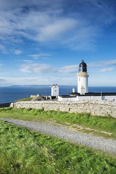Dunnet Head lighthouse on the north coast of Scotland, Orkney Islands at back on the horizon, Caithness, Scotland, United Kingdom, Europe