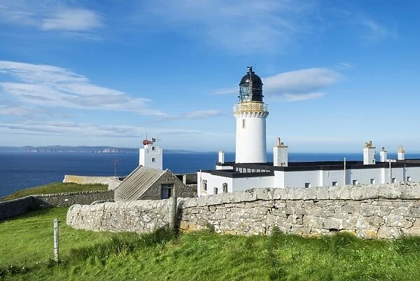 Dunnet Head lighthouse on the north coast of Scotland, Orkney Islands at back on the horizon, Caithness, Scotland, United Kingdom, Europe