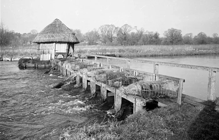 Framed Print : Eel Trap. An eel trap with a walkway and a thatched hut spanning the River Test Framed Print : Eel Trap. An eel trap with a walkway and a thatched hut spanning the River Test