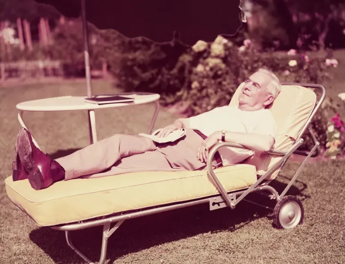 Framed Print : Elderly man relaxing on sun lounger in backyard. (Photo by H Framed Print : Elderly man relaxing on sun lounger in backyard. (Photo by H