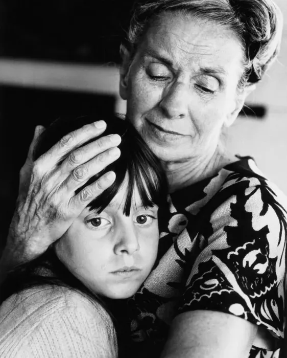 Framed Print : Elderly woman embracing and comforting forlorn-looking granddaughter