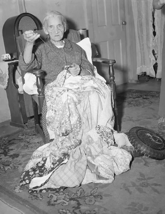 Framed Print : Elderly Woman Sews Blanket In Home Framed Print : Elderly Woman Sews Blanket In Home