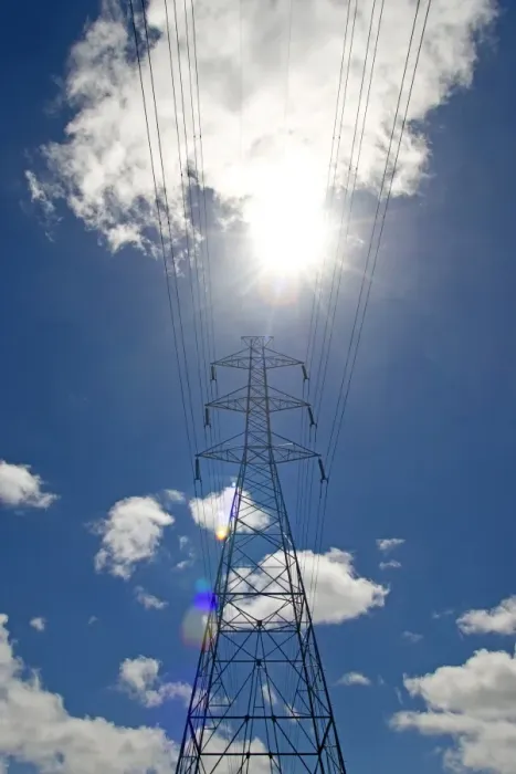 Framed Print : Electricity pylon against a blue sky with clouds