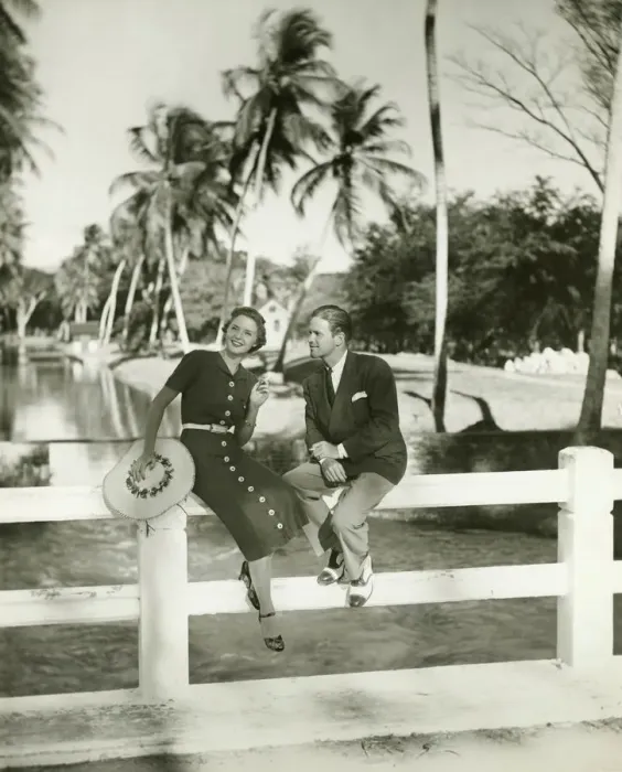 Framed Print : Elegant couple sitting on fence in tropical environment, (B&W) Framed Print : Elegant couple sitting on fence in tropical environment, (B&W)