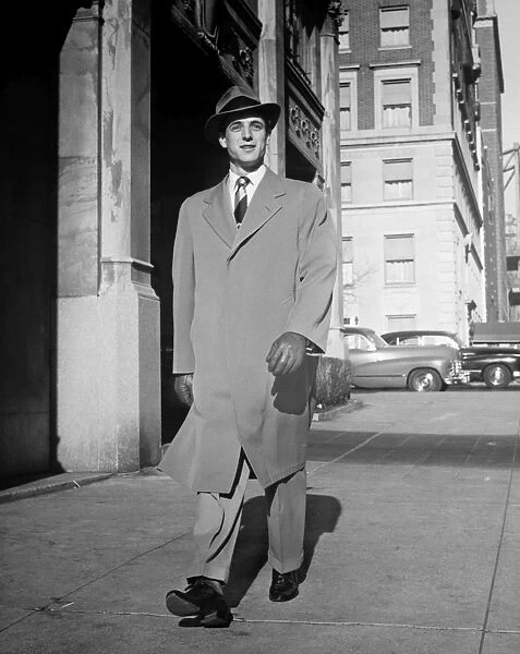 Elegant man walking alone along city street, (B&W)