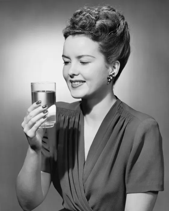 Framed Print : Elegant woman holding glass of water in studio, (B&W), portrait