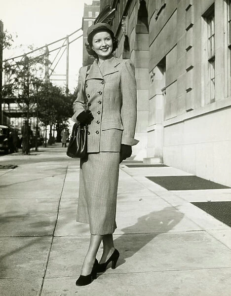 Elegant woman posing on sidewalk, (B&W), portrait
