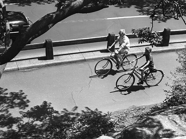 Elevated view of man and boy (12-13) cycling