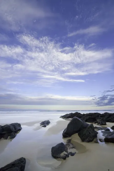 Framed Print : Eroded black rocks on beach, Australia