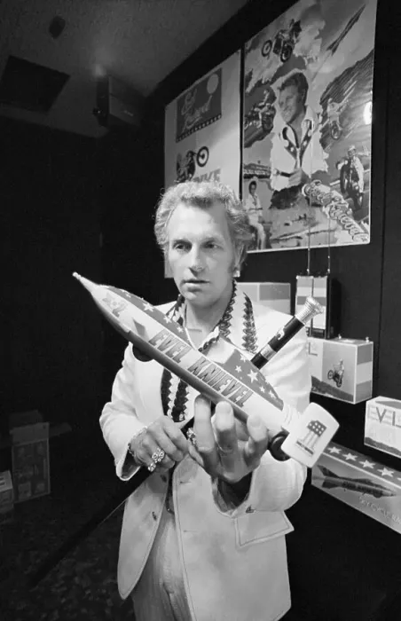 Framed Print : Evel Knievel Displaying a Model Framed Print : Evel Knievel Displaying a Model
