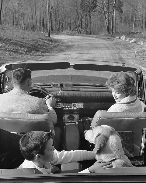 Family driving in convertible along country road