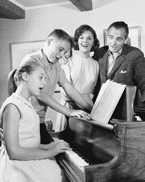 Family gathered around piano, singing