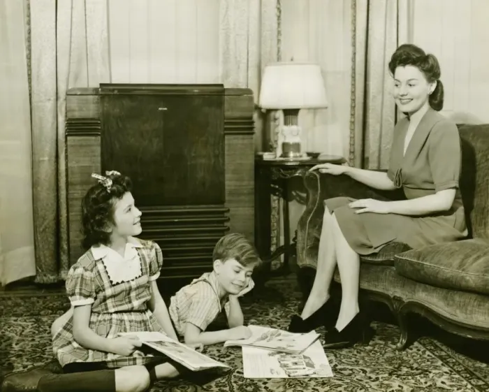 Framed Print : Family at home, children (6-7) (10-11) playing on carpet, mother sitting on sofa, (B&W) Framed Print : Family at home, children (6-7) (10-11) playing on carpet, mother sitting on sofa, (B&W)