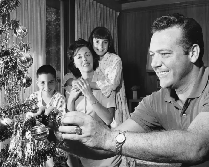 Framed Print : Family in living room, father decorating Christmas tree Framed Print : Family in living room, father decorating Christmas tree