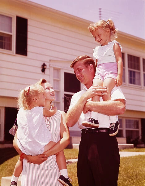 Family outside suburban home. (Photo by H. Armstrong Roberts  /  Retrofile  /  Getty Images)