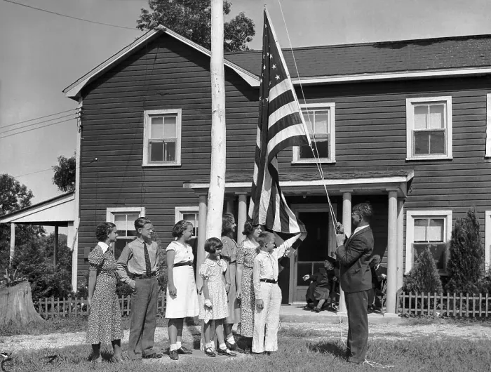 Framed Print : Family Raising Flag Outside Home Framed Print : Family Raising Flag Outside Home
