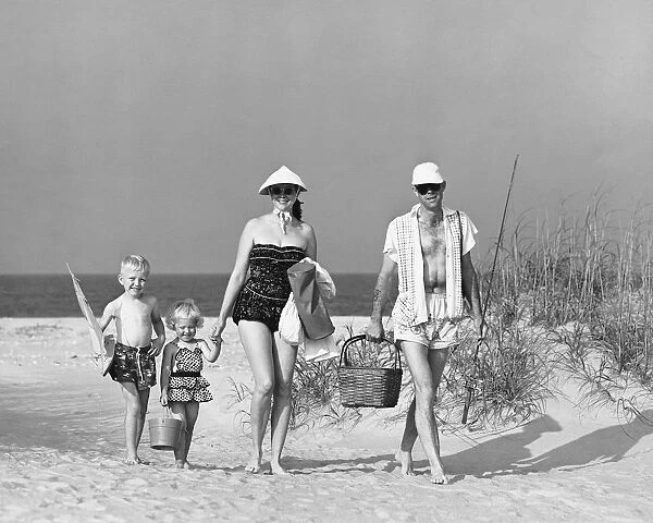 Family walking on beach, carrying fishing poles and portable cooler