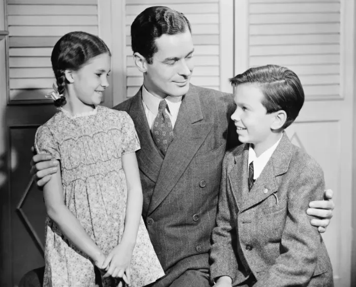 Framed Print : Father with arms around children, boy (10-11) girl (6-7), (B&W) Framed Print : Father with arms around children, boy (10-11) girl (6-7), (B&W)