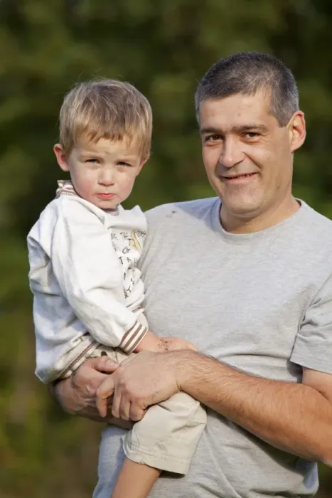 Framed Print : Father carrying his young son in his arms Framed Print : Father carrying his young son in his arms