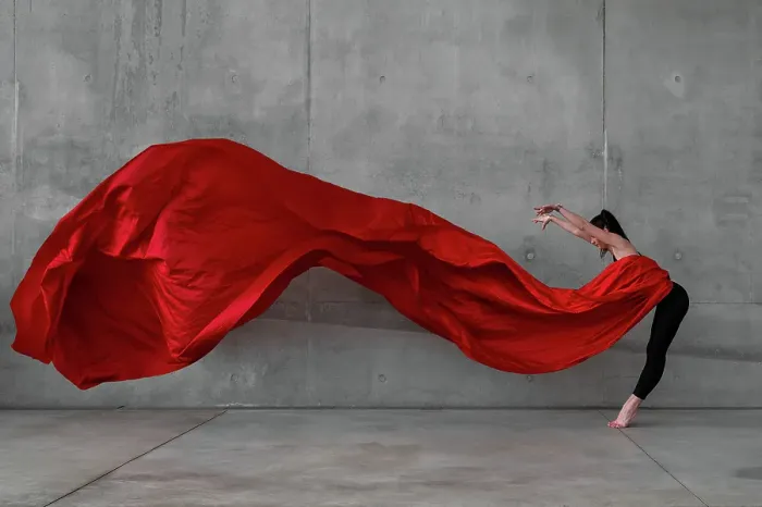 Framed Print : Female ballet dancer on pointes dancing with a large red veil in front of a grey concrete wall Framed Print : Female ballet dancer on pointes dancing with a large red veil in front of a grey concrete wall