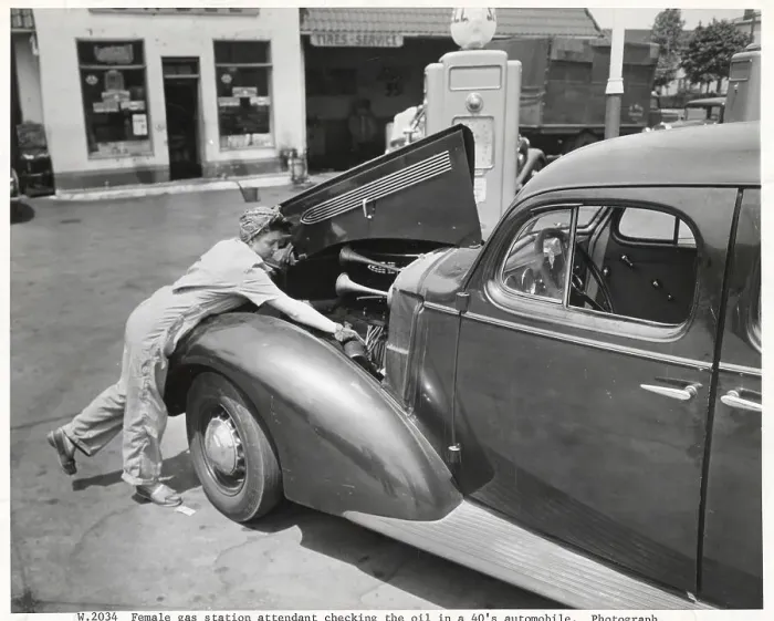 Framed Print : Female Gas Station Attendant Checking Oil Framed Print : Female Gas Station Attendant Checking Oil