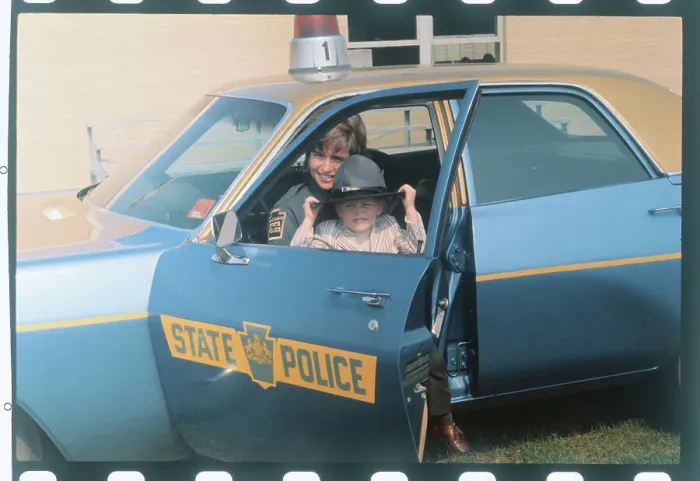 Framed Print : Female State Trooper with Son in Patrol Car