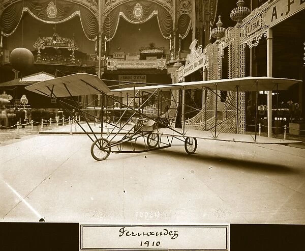 Fernandez. 25th September 1909: A Curtiss Pusher type biplane in an ornate exhibition hall