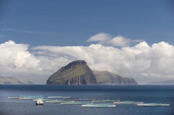 Fish farm, clouds and sea, in front of the smallest inhabited island of the Faroe Islands, Koltur, Utoyggjar, Faroe Islands, Denmark