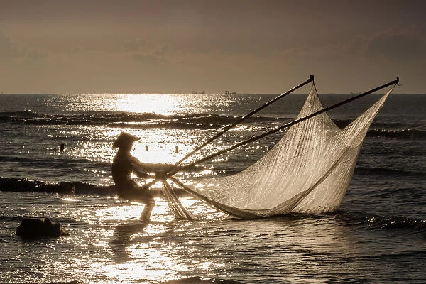One fisherman on the beach, dawn, Vietnam