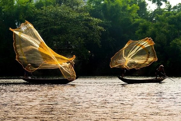 Fishermen catch fish in the river in Hue, Vietnam