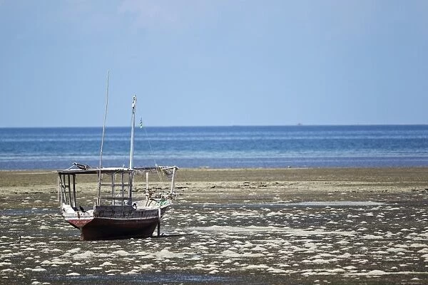 Fishing boat on the beach at low tide, near Fumba, Zanzibar, Tanzania, Africa