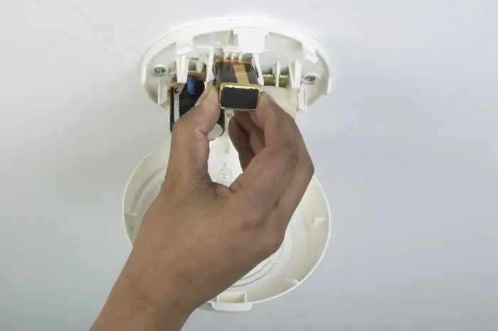 Framed Print : Fitting a battery in to a smoke alarm Framed Print : Fitting a battery in to a smoke alarm