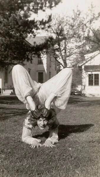 Flexible Woman in a Garden Bending Her Legs Above Her Head