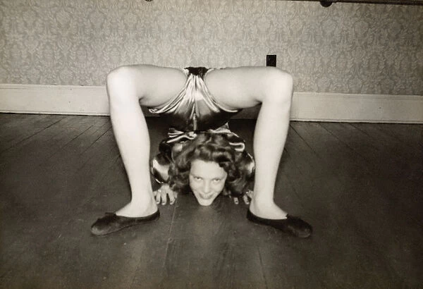 Flexible Woman on the Living Room Floor With Her Legs Over Her Head