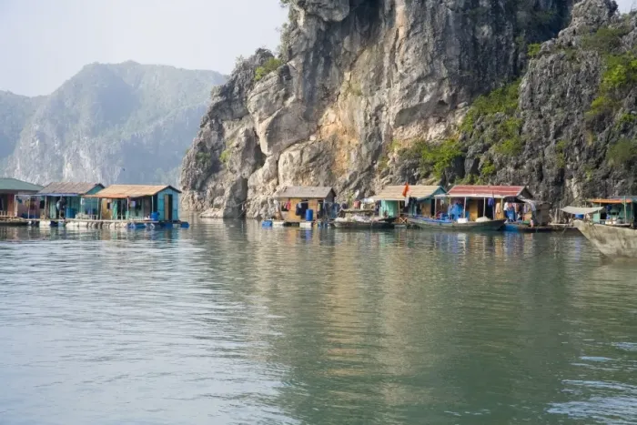 Framed Print : Floating Vietnamese fishing village at base of cliff Framed Print : Floating Vietnamese fishing village at base of cliff