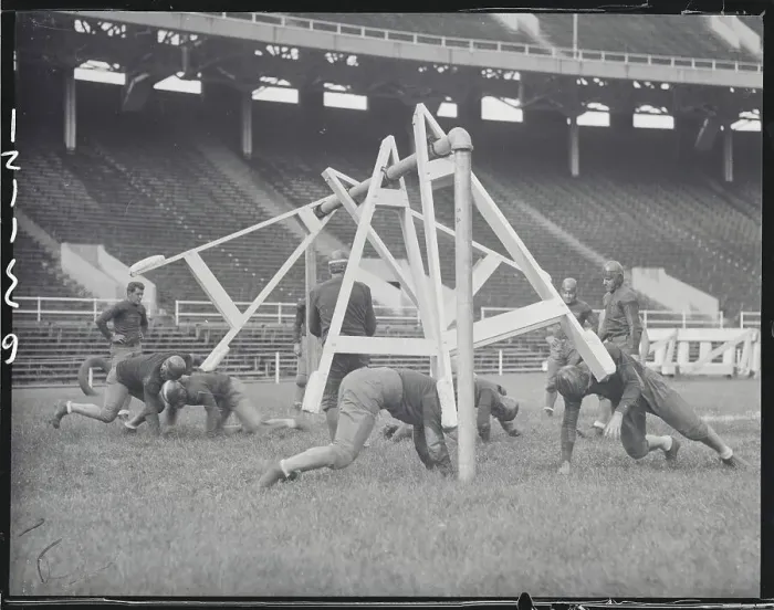 Framed Print : Football Players Practicing with New Tackling Machine