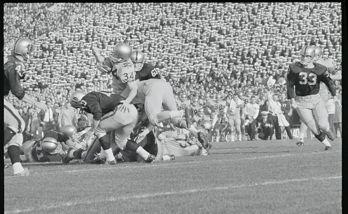 Framed Print : Football Players Tackling Their Opponent Framed Print : Football Players Tackling Their Opponent