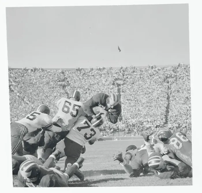 Framed Print : Football Players Tackling Their Opponent Framed Print : Football Players Tackling Their Opponent