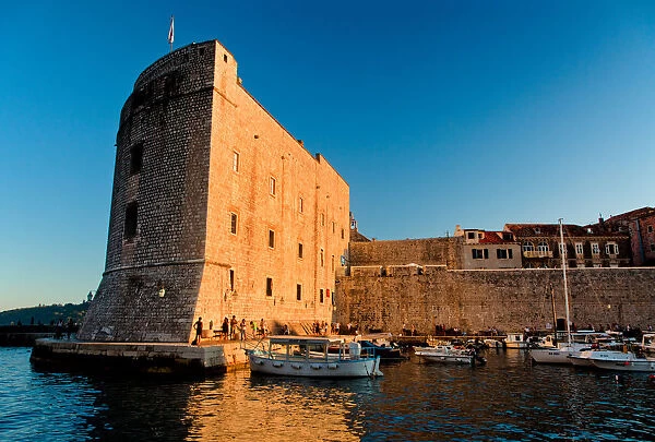 Fortress. Warm light from setting sun lights up entrance to Dubrovnik harbour