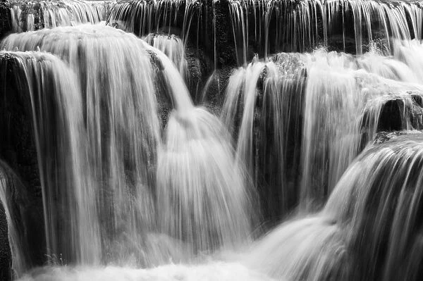 Full frame close-up of a cascade at the Tat Kuang Si Waterfalls near Luang Prabang in Laos. Natural abstract art in black and white