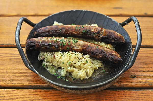 Two Franconian sausages with sauerkraut on an iron plate in a garden restaurant, Rothenburg ob der Tauber, Middle Franconia, Bavaria, Germany